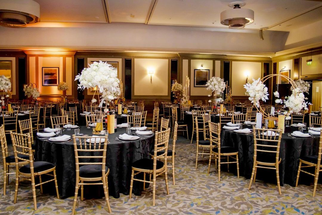 Black damask tablecloth shines in black and gold event